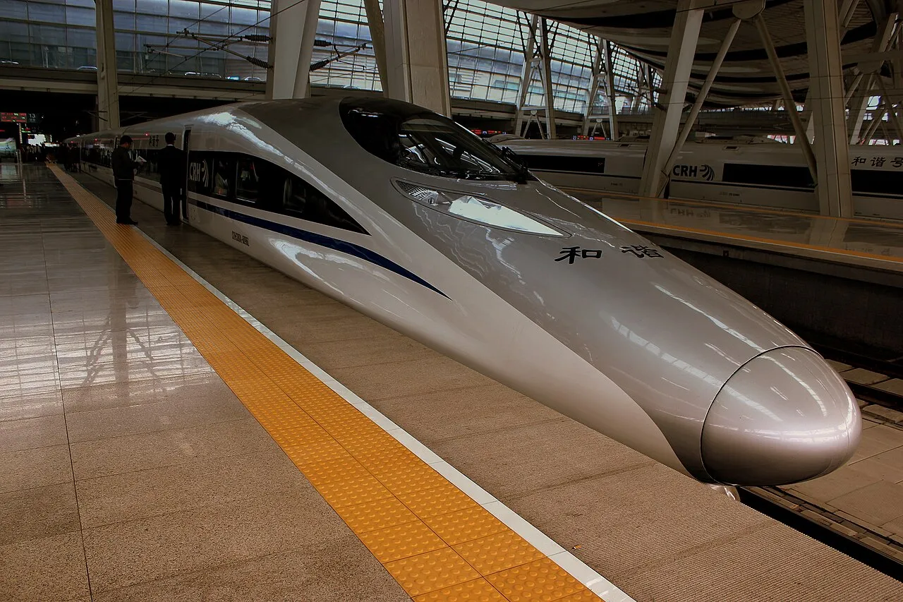 A white high-speed train waiting at a station platform